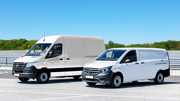 Two white Mercedes-Benz cargo vans parked on a road