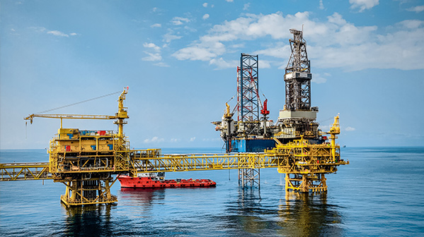 Offshore oil platform with cranes over calm blue sea